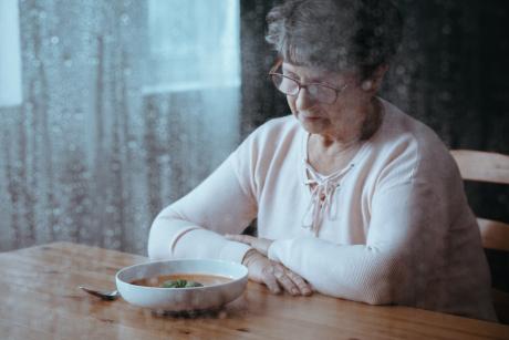 Older woman eating alone