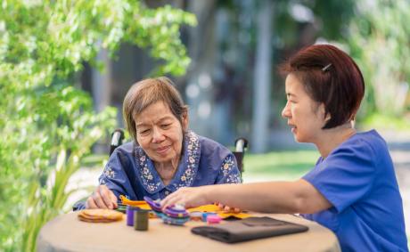Older woman with caregiver doing crafts