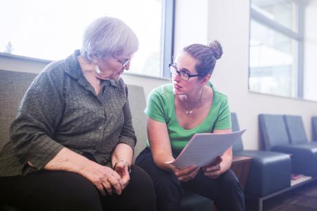 social worker helps older woman complete a questionnaire