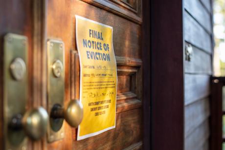 Yellow eviction notice posted on a door