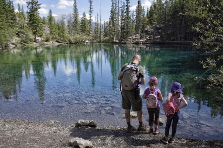 Dad and two young girls at a mountain lake