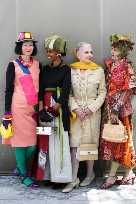 Group of 4 stylish, colorfully-dressed women smiling