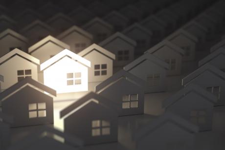 paper cutouts of housing with light shining on one