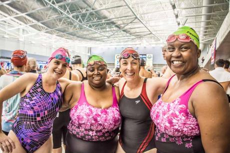 4 women at the pool smiling at the camera