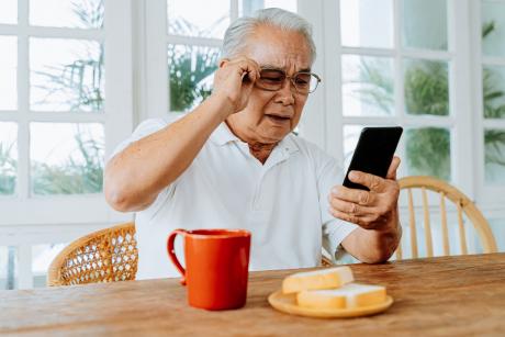 Older man having trouble seeing his phone