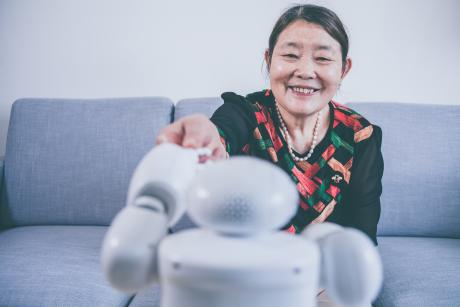 Older woman smiling at a robot
