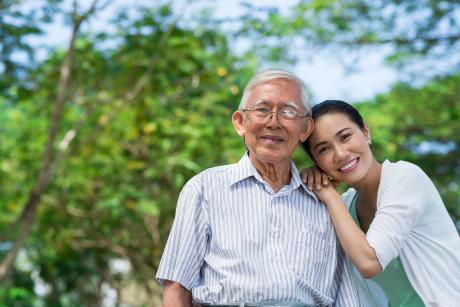 Older man with his daughter, smiling at camera