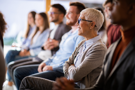 Photo of older woman in the audience at a business presentaiton
