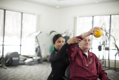 An aide helps a man do physical therapy at Hebrew Senior Life