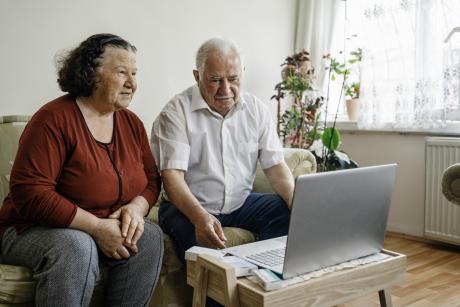 Older couple on laptop with doctor
