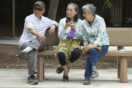 Three older Asian Americans on a park bench