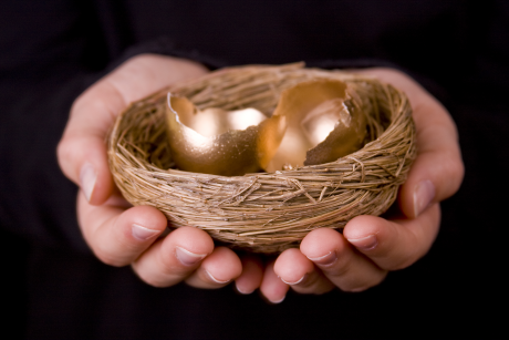 Hands holding a nest with open golden eggs