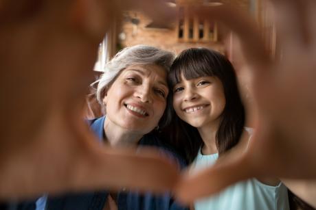 Hand heart frames woman and granddaughter
