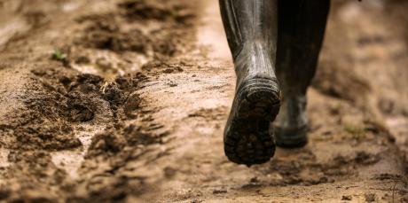 Walking on a muddy path in rain boots