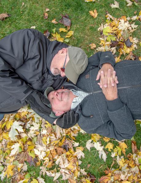 Men lie on the grass in a park