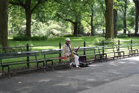 Older black man plays sax in Central Park
