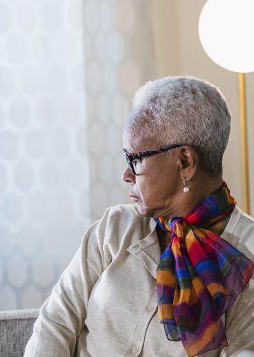 Older black woman looking to the side, contemplative