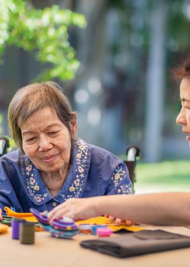 Older woman with caregiver doing crafts