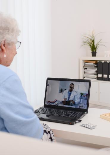 An older woman speaks with a doctor during a telehealth appointment
