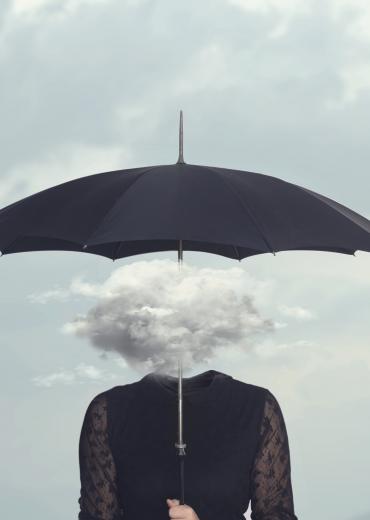 Cloud obscuring woman's head under umbrella