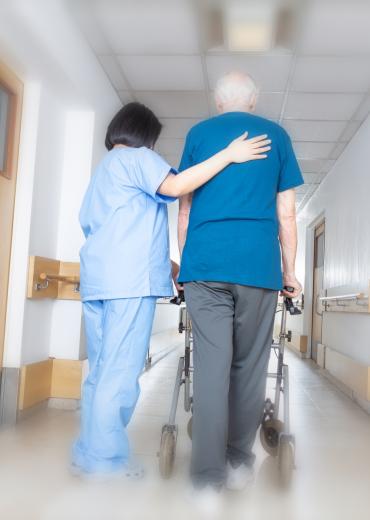 Walking down hall with assistance in nursing home