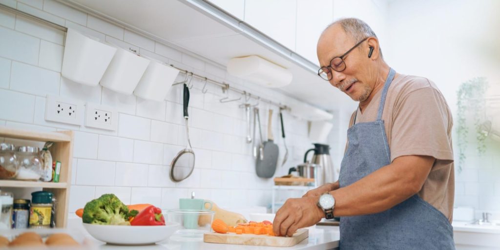 older_asian_man_cooking_healthy_meal