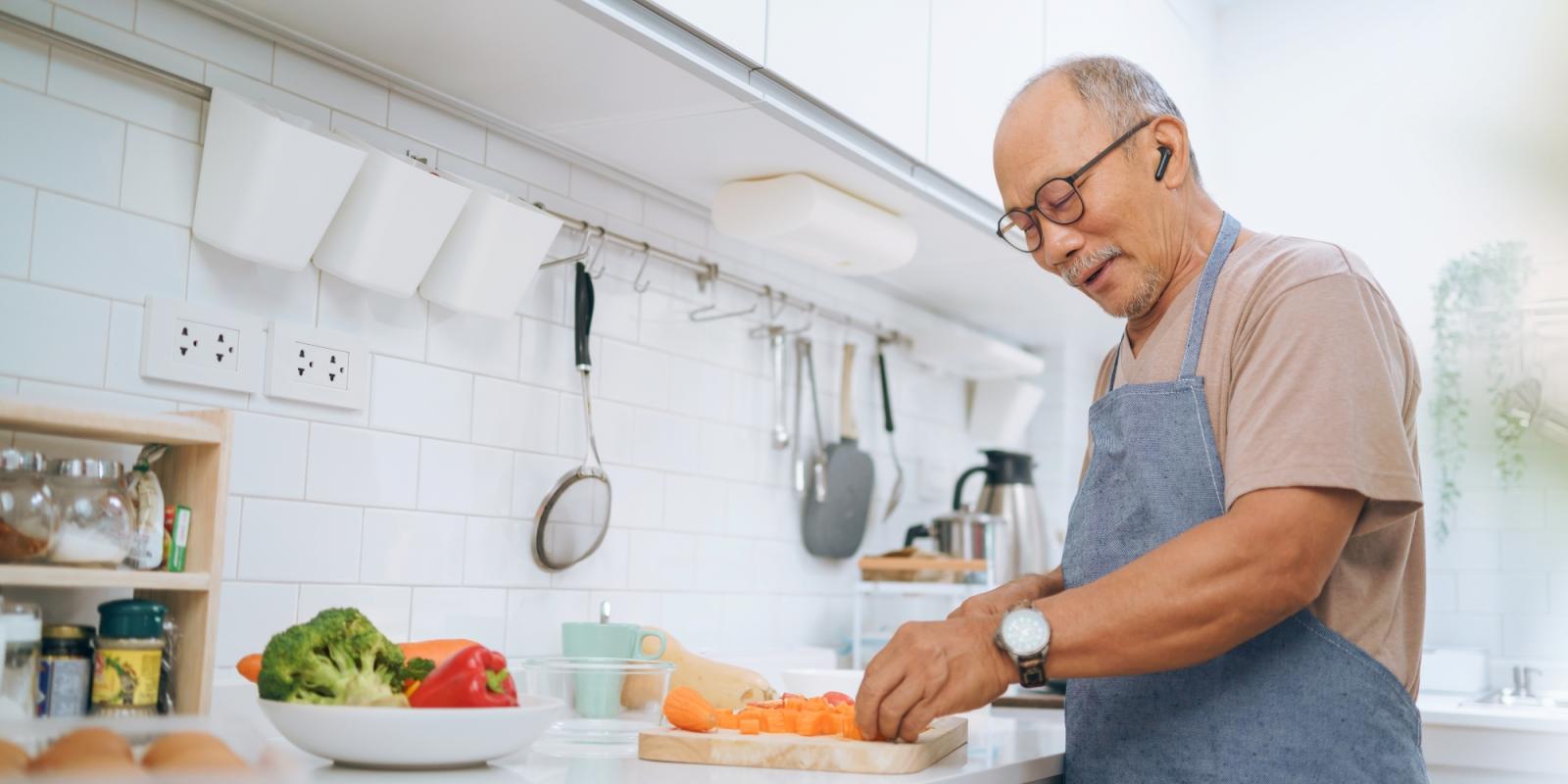 older_asian_man_cooking_healthy_meal
