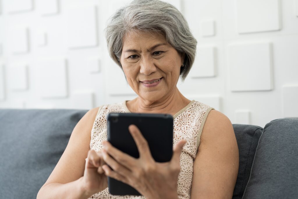 Person sitting on couch reading on their tablet.