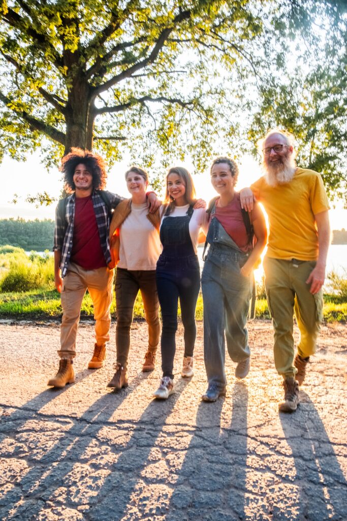 A multi-generational family enjoying a leisurely walk together during the late hours of a sunny day.