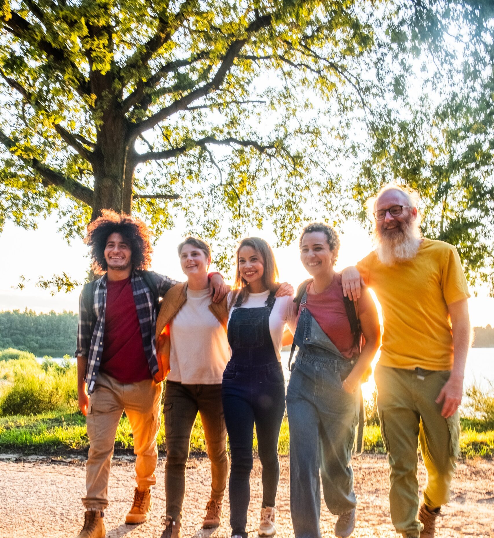 A multi-generational family enjoying a leisurely walk together during the late hours of a sunny day.