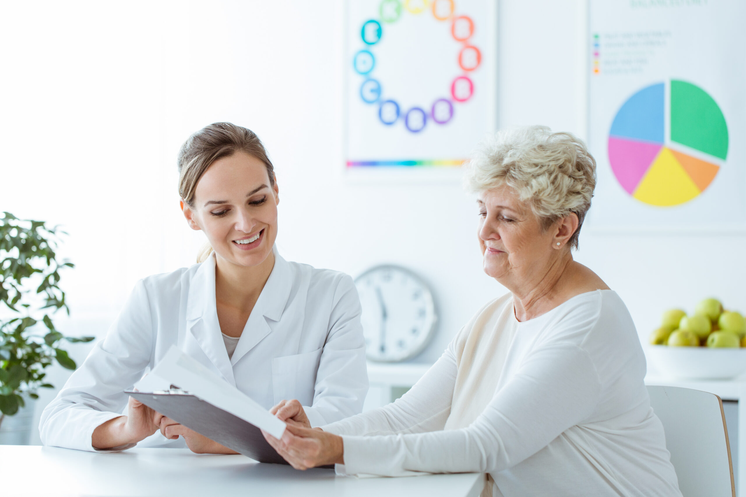 Smiling,Nutritionist,Showing,Personalized,Weight-loss,Diet,Plan,To,Her,Senior Person meeting with a dietician.
