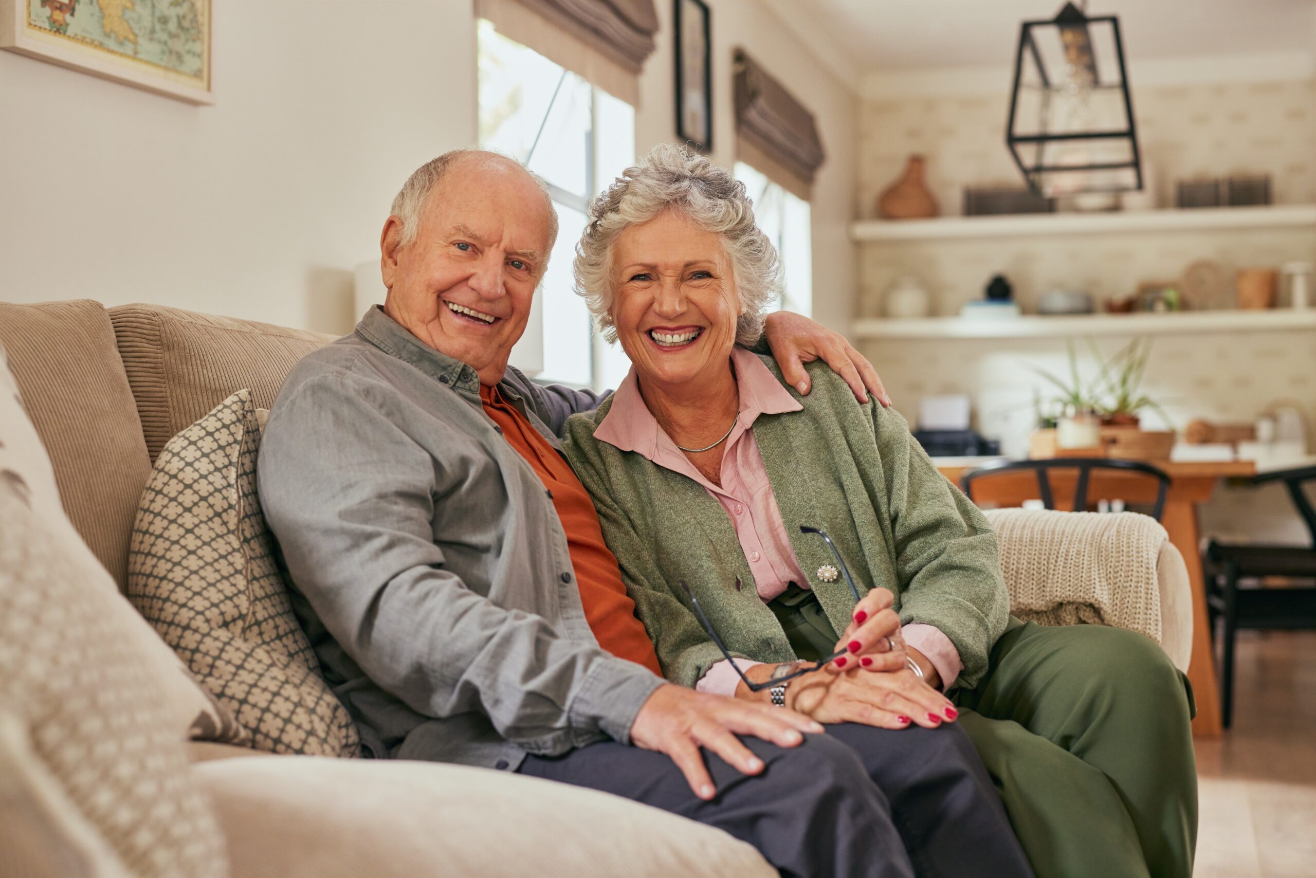 Joyful,Senior,Couple,Sitting,Together,On,A,Cozy,Sofa,At